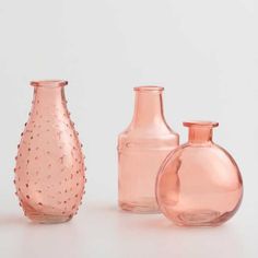 three pink glass vases sitting next to each other