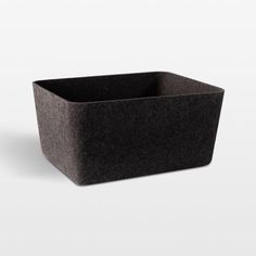 a black square container sitting on top of a white surface with no one around it