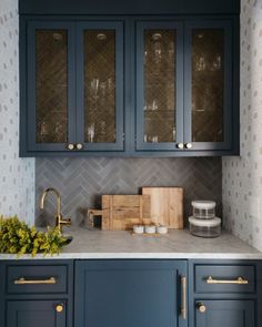 a kitchen with dark blue cabinets and gold handles on the cupboards is pictured in this image