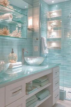 a bathroom with blue glass tile walls and white cabinetry, along with a vessel sink