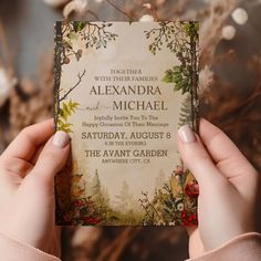 a person holding up a wedding card in front of some flowers and branches with the words, together