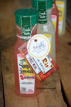 three bottles of juice sitting on top of a wooden table