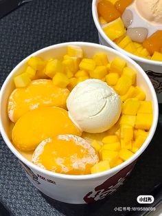 two bowls filled with fruit and ice cream on top of a black tray next to each other