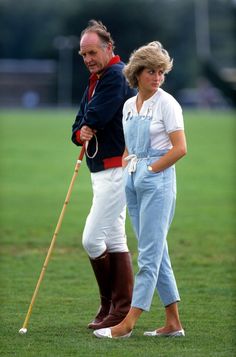 the man and woman are walking together on the grass with their canes in hand