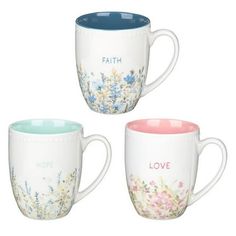 three coffee mugs with floral designs on them, one has faith and the other has love