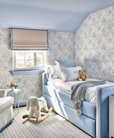 a child's bedroom with blue and white wallpaper