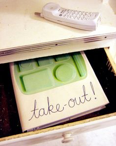 a remote control sitting on top of a table next to a sign that says take out