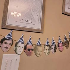 a group of people wearing party hats hanging from a line with paper cutouts on it