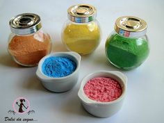 four small bowls filled with different colored powders on top of a white table next to each other