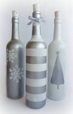 three bottles decorated with snowflakes and christmas trees