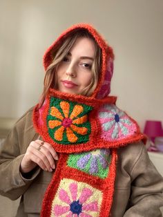 a woman wearing a colorful crocheted scarf with flowers on the front and sides