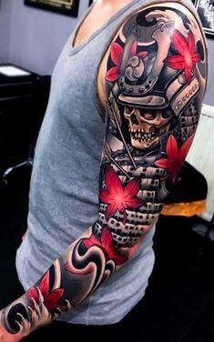 a man with a tattoo on his arm is wearing a grey shirt and red flowers