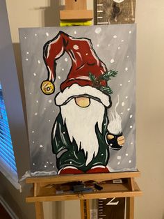 an easel with a painting of a santa clause on it