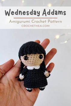 a crocheted doll in a black dress is held up with the text wednesday addams