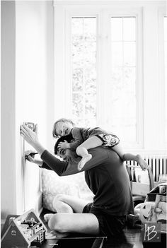 a man holding a woman in his arms while sitting on the floor next to a couch