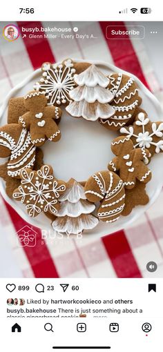 a white plate topped with lots of cut out gingerbreads on top of a red and white checkered table cloth