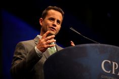 a man standing at a podium giving a speech