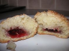 two pastries on a white plate with jam in the middle and one half eaten