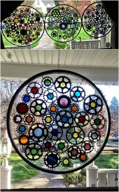 three different colored glass pieces hanging from the side of a building with trees in the background