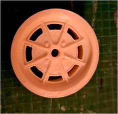 an orange plastic wheel with holes in the center