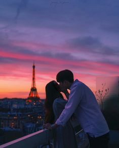 a man and woman kissing in front of the eiffel tower at sunset, paris