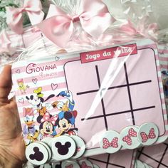 a person holding up a minnie mouse tic - tac toe game in their hand