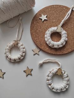 some white string and wooden stars are on a cork board next to twine spools