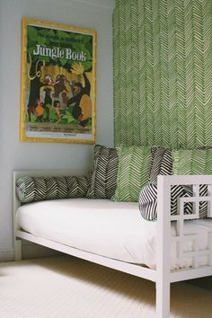 a white day bed sitting in a bedroom next to a green wall