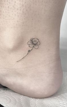 a small flower on the side of a woman's foot is shown in black and white