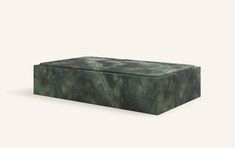 a green marble box sitting on top of a white surface