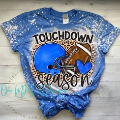 a blue tshirt with an image of a football helmet and the words touchdown season on it