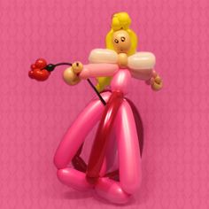 a pink balloon with a girl on it's back holding a cherry in her hand