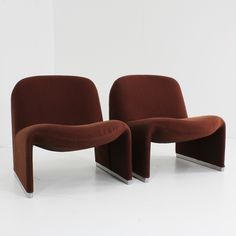 two brown chairs sitting next to each other on a white floor