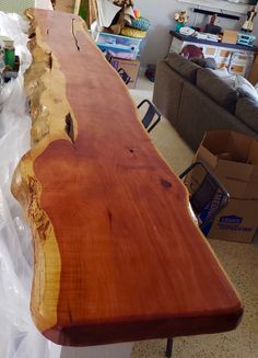 a long wooden table sitting on top of a hard wood floor next to a couch