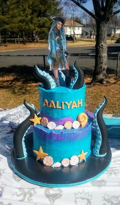 a blue and purple cake with an image of a woman on top