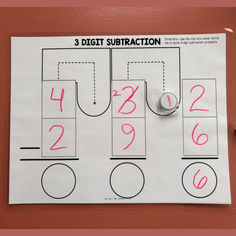 three digit subtraction game on a bulletin board with marker and paper clipping