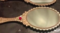 two mirrors sitting on top of a counter next to each other with a red bead in the middle