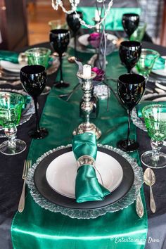 the table is set with black and green dishes