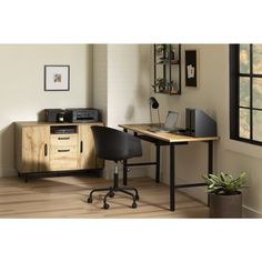 a desk with a laptop and printer on top of it next to a potted plant