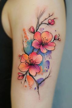 a colorful flower tattoo on the back of a woman's left arm and shoulder