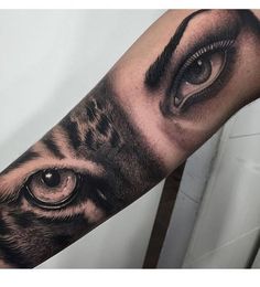 a tiger eye tattoo on the left forearm and right arm with an eyeball in it