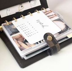 a binder with two photos attached to it sitting on top of a desk next to a pair of shoes