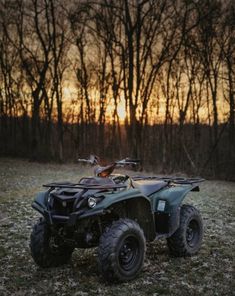 an atv is parked in the grass near trees