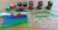 chocolates and candy wrappers sitting on top of a wooden table with googly eyes