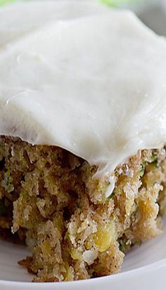 a close up of a piece of cake on a plate with white frosted topping