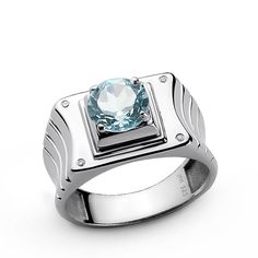 a white gold ring with a blue topazte in the center on a white background