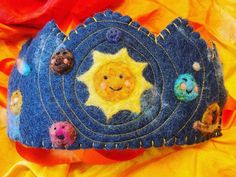 a blue felt crown with small faces on it