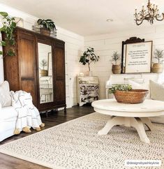 a living room filled with furniture and a white table in front of a wooden cabinet