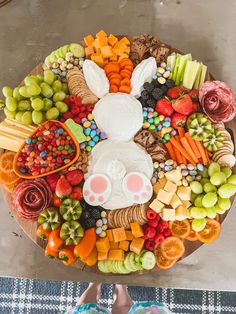 a platter filled with lots of different types of fruit and veggies on top of a table