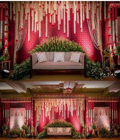 red and white wedding decor with flowers on the wall, couches and drapes